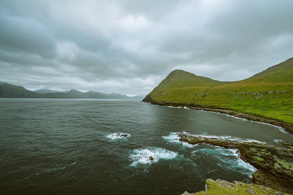 Aerial view of the rugged coastline and lush landscapes of Sandoy, Faroe Islands.